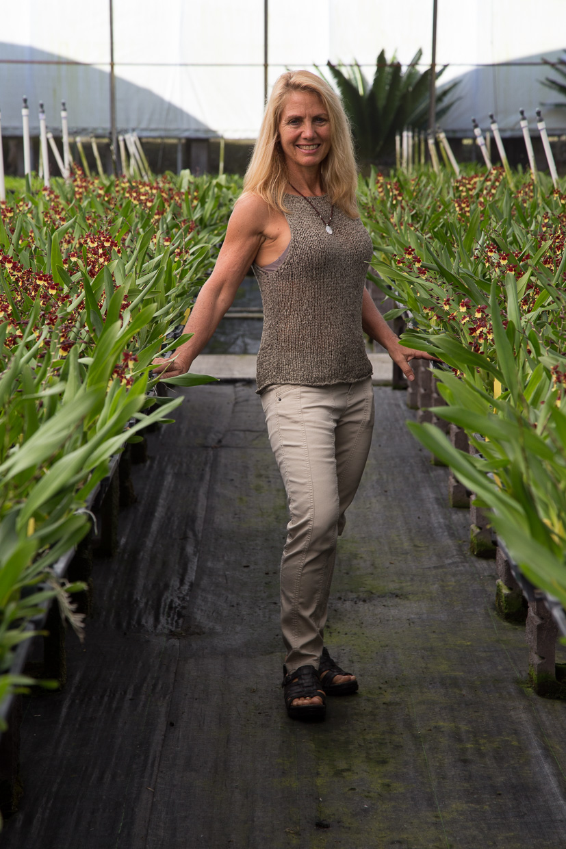 Melinda standing in front of orchids.